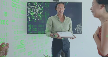 Presenting man in light green shirt with tablet at office, screen with green fireworks overlay