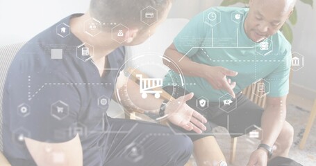 Talking two men wearing navy and teal tees, pointing at leg sensor in lounge, shopping-cart overlay