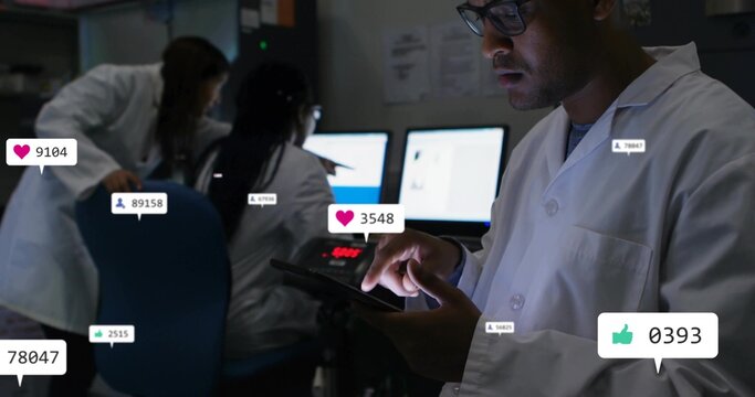 Tapping man wearing lab coat, glasses using tablet at lab, monitors social icons, copy space