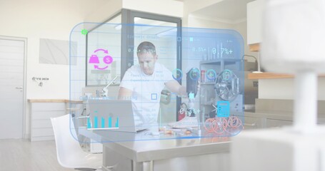 Leaning mature man studying laptop at steel table in kitchen, wearing white t-shirt, viewing HUD