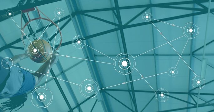 Leaping basketball player with braids reaching rim at arena, holding ball, blue jersey, copy space