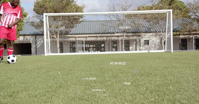 Standing player wearing red-white kit and cleats on pitch with soccer ball white goal, copy space - Powered by Adobe