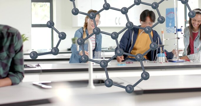 Working students in lab wearing navy and denim jackets handling glassware, with molecular model