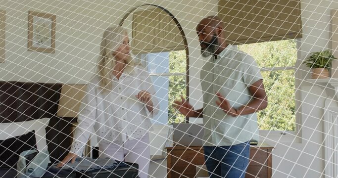 Packing woman in white blouse filling open suitcase on bed in bedroom, man gesturing near dresser