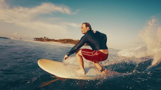 Surfer rides the ocean wave in the Maldives. In water and underwater view of the surfer on the wave