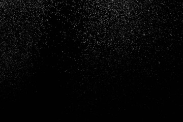 The falling white snow on a black background