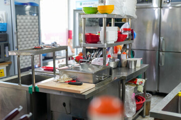 A kitchen with a counter top and a sink. There are many bowls and spoons on the counter