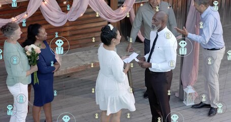 Groom starting vow reading, bride sharing vows, wedding guests smiling, icons floating over scene - Powered by Adobe