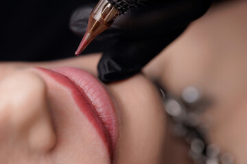 Top view Macro photo process of applying microblading permanent makeup tattoo of red on lips woman