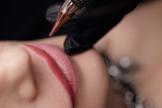 Top view Macro photo process of applying microblading permanent makeup tattoo of red on lips woman