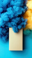 A beige book with blue, yellow and green smoke on a blue background. Abstract and colorful.