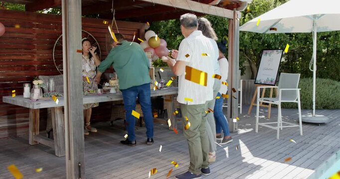 Guests serving at backyard event buffet after server placing items, gold confetti landing on guests
