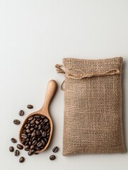 Overhead shot of coffee beans in a wooden scoop and a burlap sack on a white background.