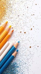 Top-down shot of colored pencils in various colors with gold and blue glitter on a white background. The image has a festive and creative feel.