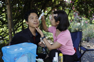 Woman and man applying skin care cream and sunscreen.