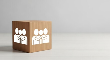 Wooden cube with people icons representing partnership, collaboration, support and inclusive teamwork on clean desk background for human resources and culture concepts