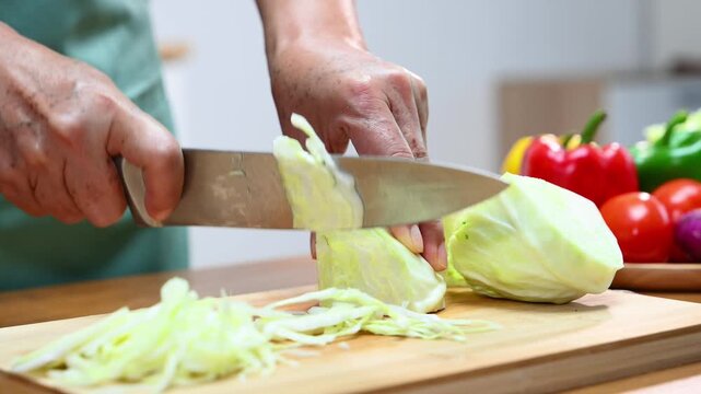 Slicing fresh cabbage and vegetables for a healthy meal prep, showcasing cooking skills with organic ingredients and kitchen tools for a delicious and nutritious recipe.