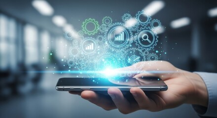 Futuristic mobile data analytics and cloud technology concept with holographic charts, gears and digital icons rising from smartphone screen in modern office environment

