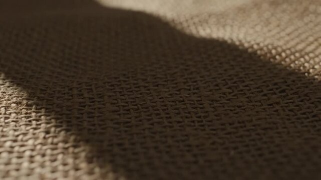 Closeup of natural brown burlap fabric with textured weave and shadow