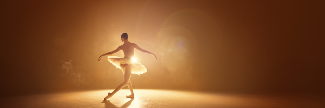 Solo ballet dancer illuminated in atmospheric golden haze. Concept of dramatic storytelling, artistic promotion, emotional branding, premium visuals, atmospheric creative design. - Powered by Adobe