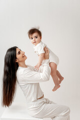 a mother holds her baby in her arms, hugging and kissing it, space and place for text, mother and child, maternal love