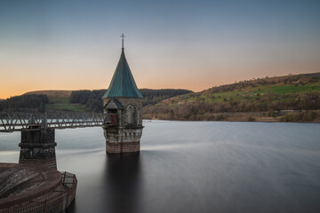 Bell-mouth spillway and valve tower at Pontsticill Reservoir (Taf Fechan Reservoir) in south Wales at sunset