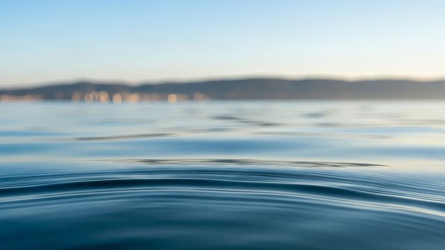 Sea Serenity Calm blue water reflecting sunlight with with hills in the distance. - Powered by Adobe