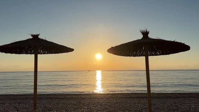 Parasol with sunrise on the beach in Albir Spain
