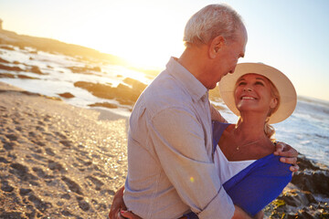 Love, hug and mature couple by beach on summer vacation, getaway or weekend trip together. Sunset, happy and man with woman for embracing with care, connection or bonding by ocean on holiday travel.