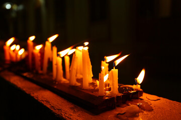 Close-up of lighting a candle with a match in the dark, Burning candles on dark surface. Memory day
