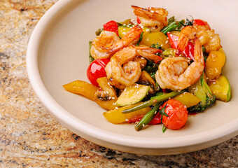 Fresh shrimp stir-fry with colorful vegetables on a marble table