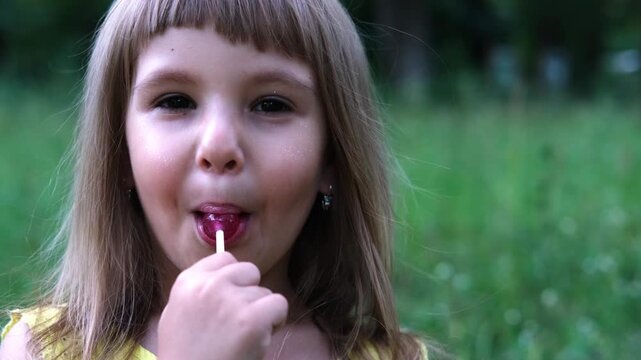 portrait of a little beautiful girl sucking on a lollipop