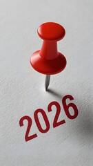 Red Push Pin with '2026' Painted on White Surface