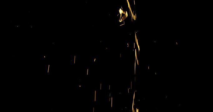 Splashes of liquid web in rays of golden light against the black insulated background of the studio