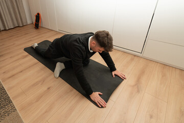 Man stretching hip flexor on yoga mat at home