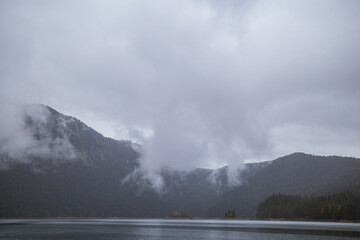 Fototapeta premium Cloudy mountain landscape with mist over the lake