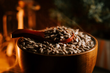 Peeled roasted sunflower seeds in a wooden bowl with a spoon on a rustic table