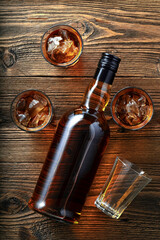 Scotch whiskey bottle and glasses on stone table. With copy space. Top view flat lay