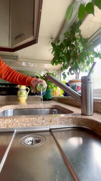 vaciando botella de agua t&eacute;rmica en el fregadero