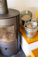 Wood stove with buckets of ash and shovel for cleaning