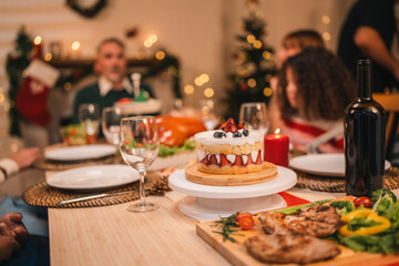 Family gathering around festive dinner table celebrating winter holiday with joyful atmosphere sharing happiness delicious meal warm decorations and emotional connection during Christmas evening