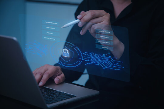 A person interacts with a holographic display while using a laptop, showcasing advanced technology and digital security features.