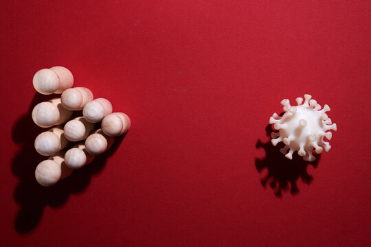 3d printed  virus with wood figurine against color background
