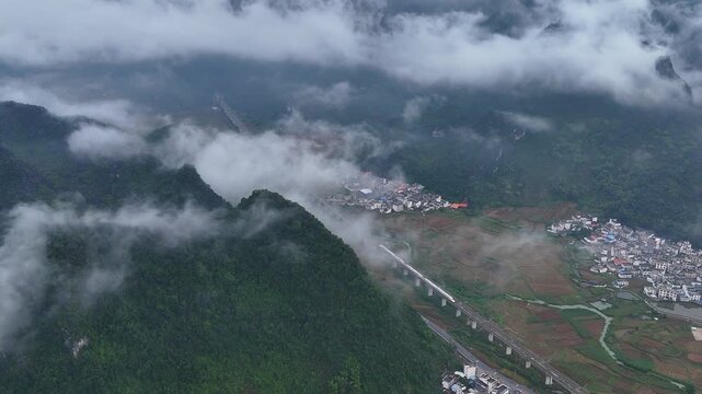 Morning Fog Over Karst Basin with High-Speed Rail and Villages