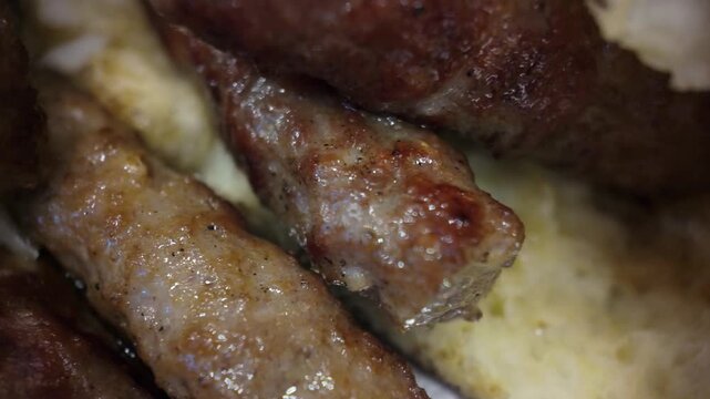 Macro close-up of cevapi showing juicy grilled texture as the camera moves left, capturing fine details of traditional Balkan meat