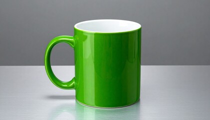 A bright green ceramic mug with a glossy finish sits on a reflective metallic surface, its white interior and rounded handle highlighted against a neutral gray background.
