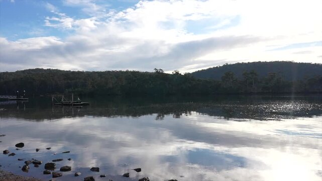 Pambula lake calm and still reflecting the clouds in the sky, New South Wales, Australia