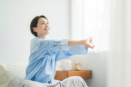 朝起きてストレッチをする女性
