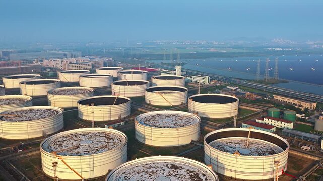 Aerial shot of large white oil storage tanks in petrochemical refinery plant in industrial area