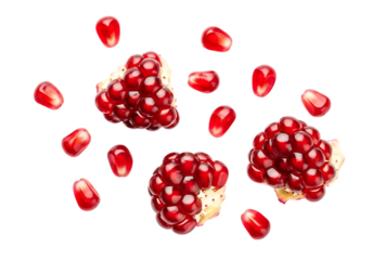 Vibrant arils and fragments of ripe pomegranate scattered against a stark black background